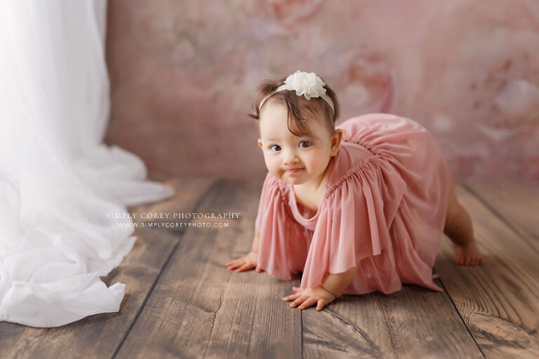 baby photographer near Dallas Georgia, girl in pink crawling by white curtains
