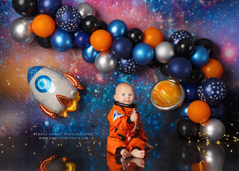 baby photographer near Newnan, outer space studio set with balloons and orange astronaut suit