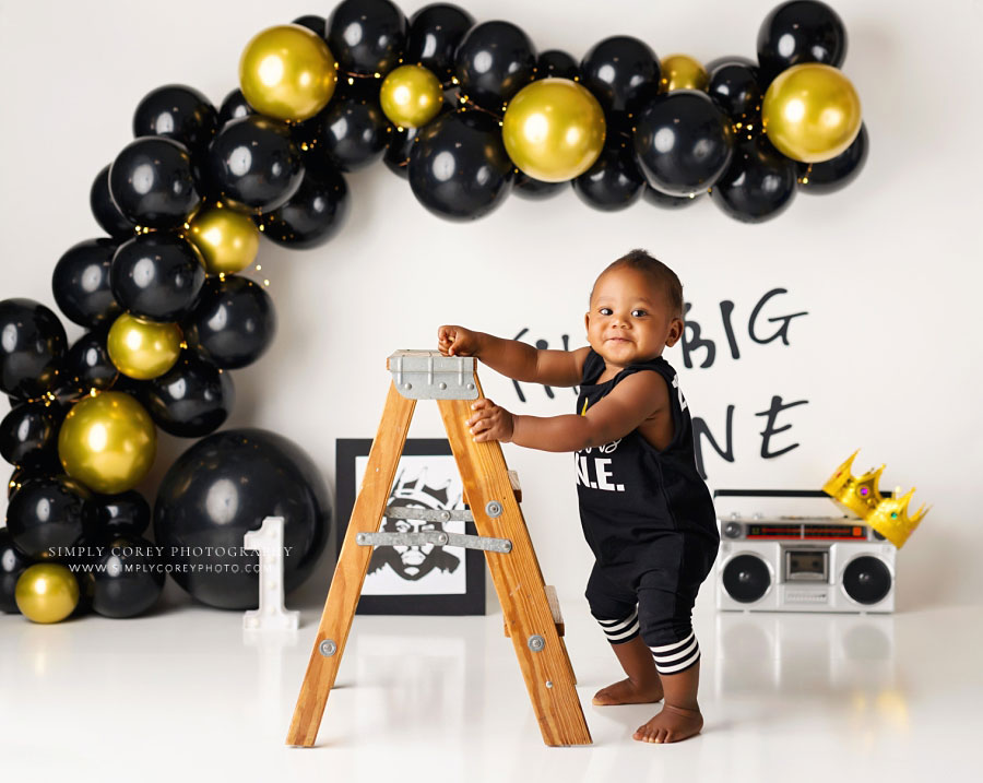 baby photographer near Dallas, GA; boy standing with ladder for one year milestone session