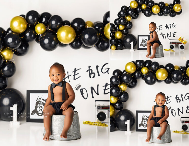 Villa Rica baby photographer, boy in studio with bow tie and black gold balloon garland