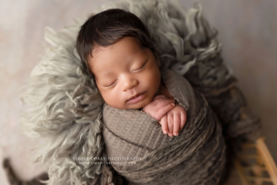 Carrollton newborn photographer in GA, baby boy wrapped in brown swaddle