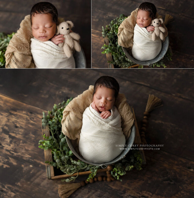 Hiram newborn photographer, baby boy in bucket with ivory swaddle and greenery