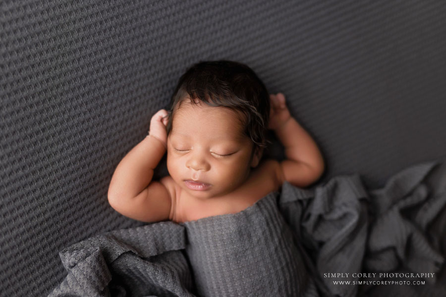 newborn photographer near Carrollton, GA; baby boy in gray studio set