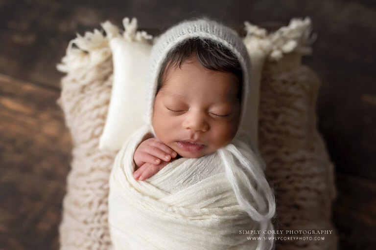 newborn photographer near Powder Springs, baby boy in ivory swaddle and hat in studio