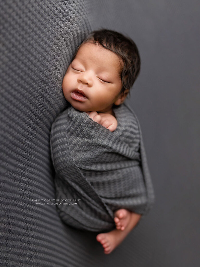 Newnan newborn photographer, baby boy in gray swaddle during studio session