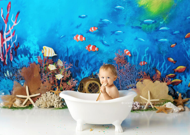 cake smash photographer near Atlanta, baby boy in bathtub on ocean studio set for first birthday