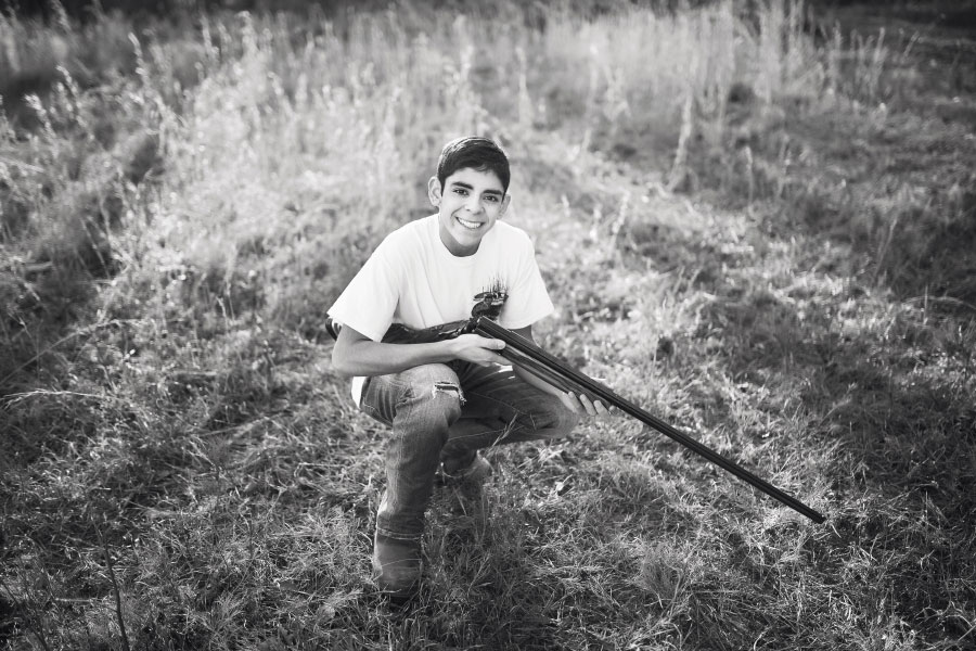 Carrollton senior portrait photographer in Georgia, teen outside with rifle