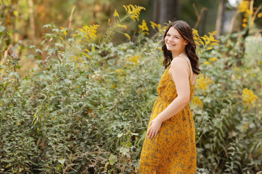 Newnan senior portrait photographer, teen outside with yellow flowers