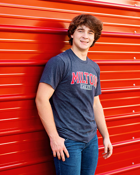 senior portrait photographer near Atlanta, teen near red wall