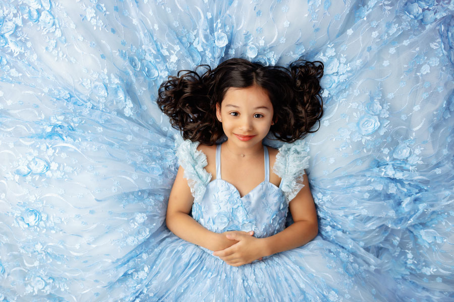 Villa Rica dream dress photographer for kids, girl lying down in blue dress