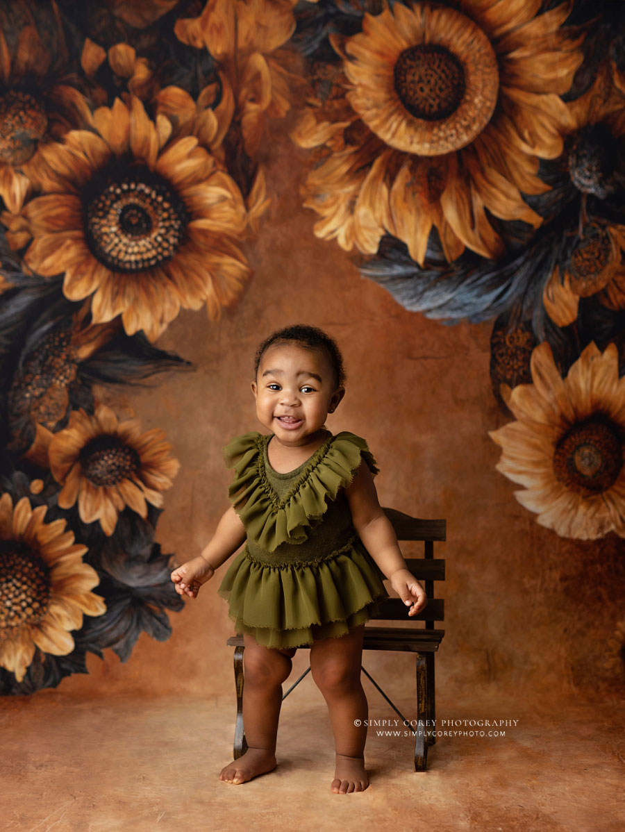 Douglasville baby photographer, girl in green with sunflower studio backdrop