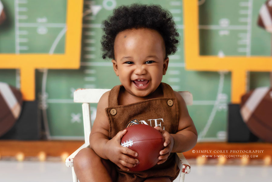 Villa Rica baby photographer, boy with big smile holding a football
