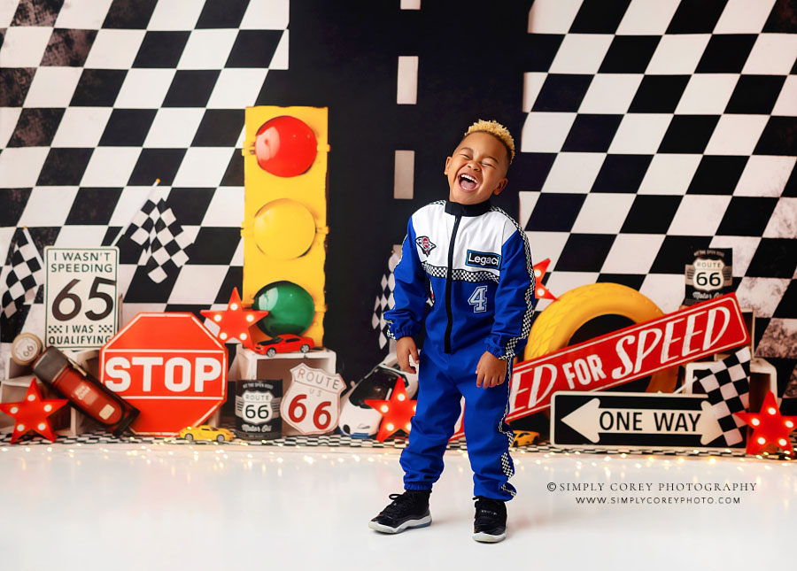 children's photographer near Atlanta, boy laughing on race car studio set for birthday