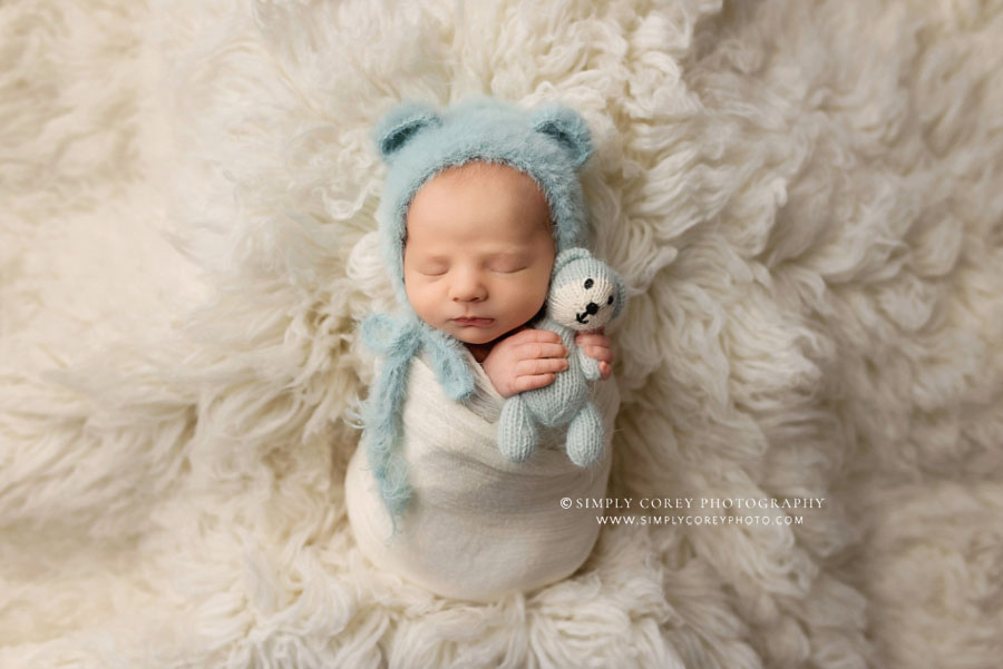 newborn photographer near Bremen, baby boy in bear hat on flokati fur