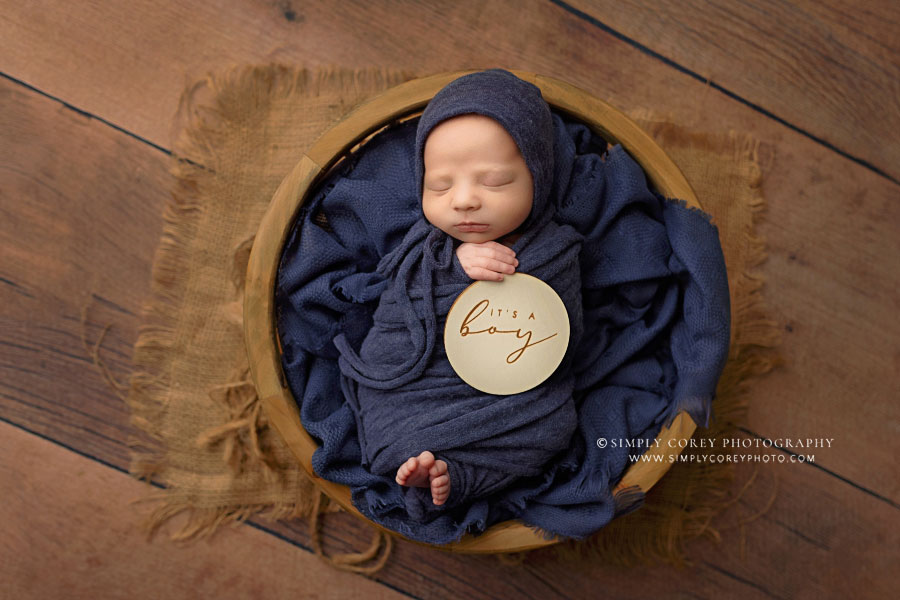 Temple newborn photographer, baby boy in blue holding a wood sign