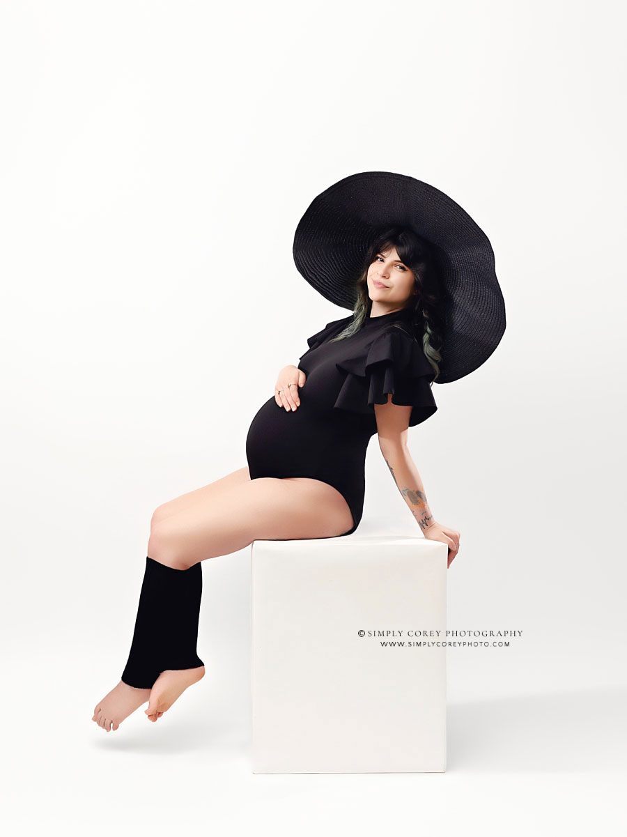 maternity photographer near Atlanta, white studio backdrop with box and floppy hat