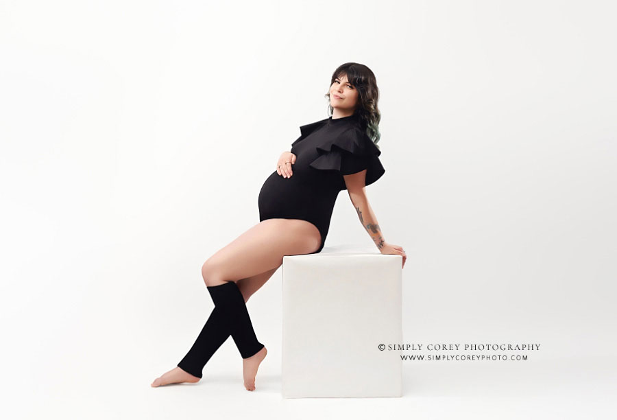 maternity photographer near Newnan, simple studio portraits with black bodysuit and white backdrop